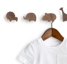 three wooden animals hang on a clothesline next to a t - shirt with a pocket