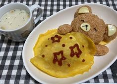 a teddy bear is sitting next to some food on a plate with a cup of coffee