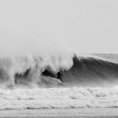 a man riding a wave on top of a surfboard