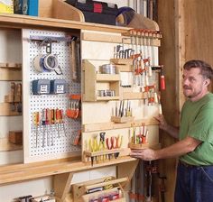 a man standing next to a workbench filled with tools