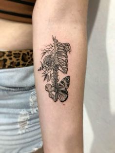 a woman's arm with a butterfly and flower tattoo on the left inner arm