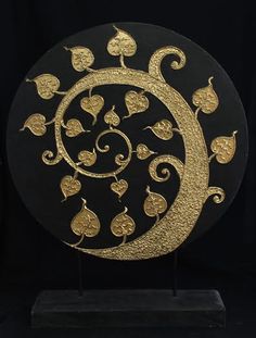 a black and gold plate with swirls and hearts on the side, in front of a black background