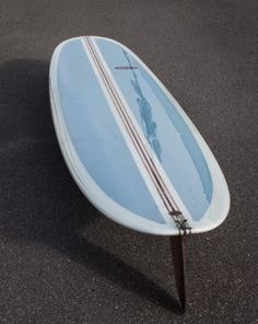 the surfboard is laying on its side in the parking lot with no one around it