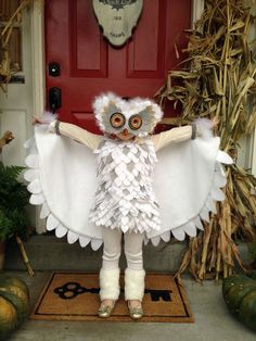 a doll is dressed in white and standing on the front porch with her arms outstretched