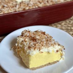 a piece of cake sitting on top of a white plate next to a casserole dish