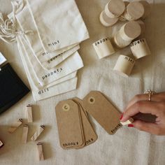 a table topped with lots of wooden tags and other crafting supplies on top of a white cloth