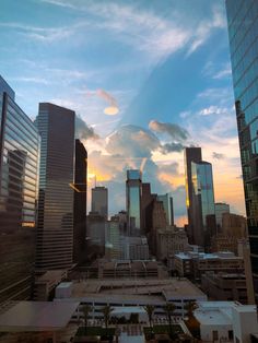 the sun is setting over a city with tall buildings and skyscrapers in the foreground