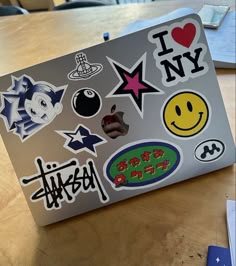 an apple laptop covered in stickers on a table