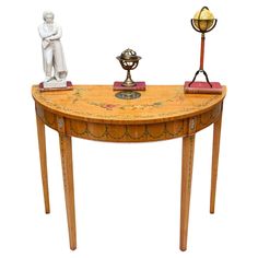 a table with two statues on it and a lamp in the middle, sitting next to each other