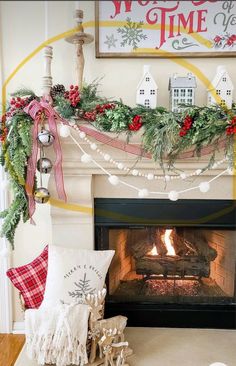 a fireplace decorated for christmas with stockings and garland