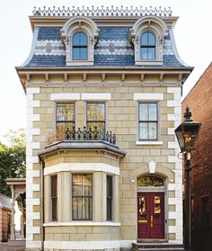 the front of a two story house with a red door