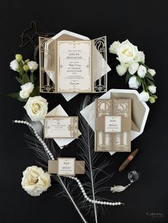 the wedding stationery is laid out on top of each other, with white flowers and greenery