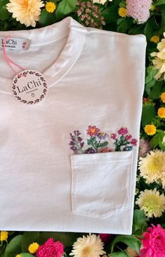 a white t - shirt with flowers on it and a tag that says lacci