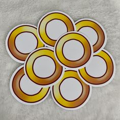 six yellow and brown circles stickers sitting on top of a white carpeted floor