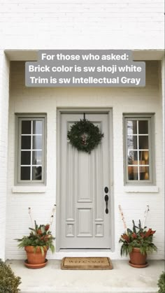 a white house with two potted plants and a wreath on the front door that says, for those who asked brick color is swi