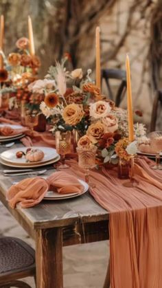 a long table with candles and flowers on it is set up for an outdoor dinner