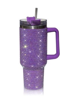 a purple cup with a straw in it and some diamonds on the side, sitting next to a white background