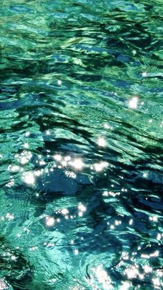 the water is very clear and blue with little white dots on it's surface