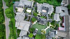 an aerial view of a house in the middle of trees and bushes, with lots of windows