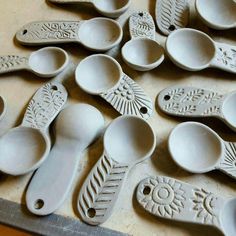 many spoons are lined up on a table with holes in the middle to hold them