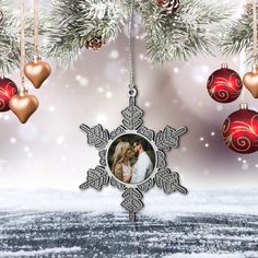 an ornament hanging from a christmas tree decorated with ornaments and snowflakes