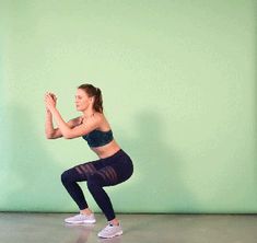 a woman in black sports bra top and leggings doing squat exercises