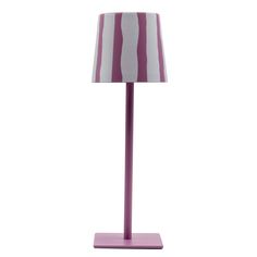 a purple and white lamp with a striped shade on the top, sitting on a pink base