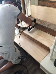 a man is sanding the steps with a power drill and an air blower