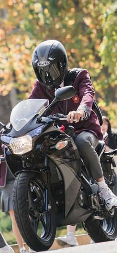 a man riding on the back of a black motorcycle