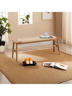 a wooden bench sitting on top of a rug in a living room next to a potted plant