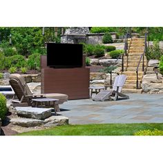 a patio with chairs and a television in the back ground, surrounded by stone steps