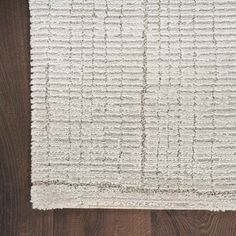 a white rug on top of a wooden floor next to a wood flooring board