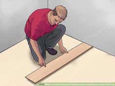 a man kneeling down on top of a piece of wood with his hands in the floor