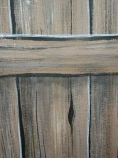 a close up of a wooden door with peeling paint on the side and wood slats in the background