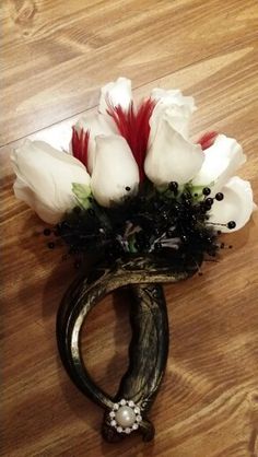 a bouquet of white flowers sitting on top of a wooden table