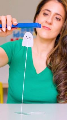 a woman holding a toothbrush with a fake ghost on it