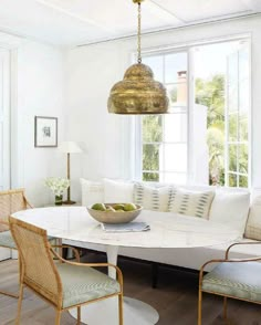 a living room with white couches and chairs in front of a large round table