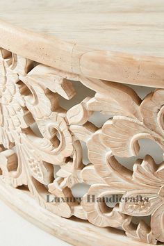 an ornate carved wooden table with wood carving on the top and bottom, along with a white background