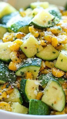 a white bowl filled with cucumber and corn salad on top of a table