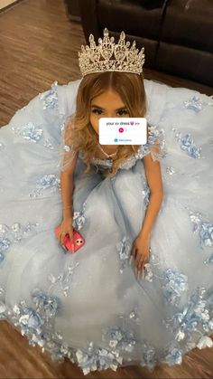 the doll is wearing a blue dress and tiara