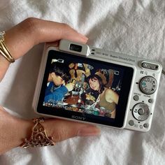 a person holding up a camera with pictures on it