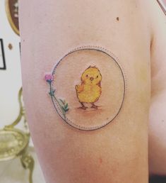 a small yellow bird on the side of a woman's thigh with a flower in it