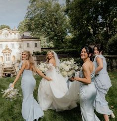 four bridesmaids are walking in the grass with their bouquets and dresses on