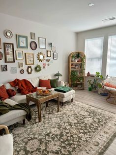 a living room filled with furniture and lots of pictures on the wall above it's windows