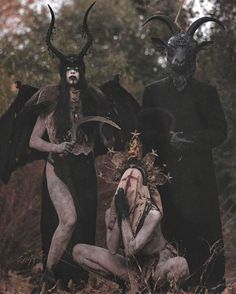 three people dressed up as devil and demon in the woods with horns on their heads