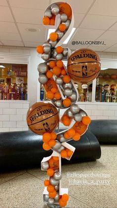 an orange and silver sculpture with basketballs on it