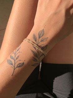 a close up of a person's arm with leaves on it and a string around the wrist