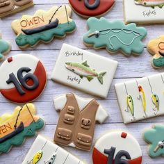 decorated cookies with fishing related items displayed on white tablecloths and wood planks