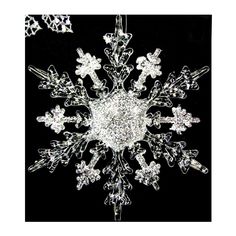 a snowflake that is on top of a black surface with white and silver decorations