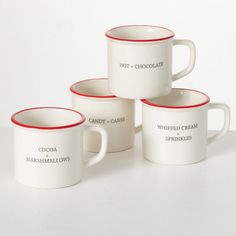 four coffee mugs sitting on top of a white table